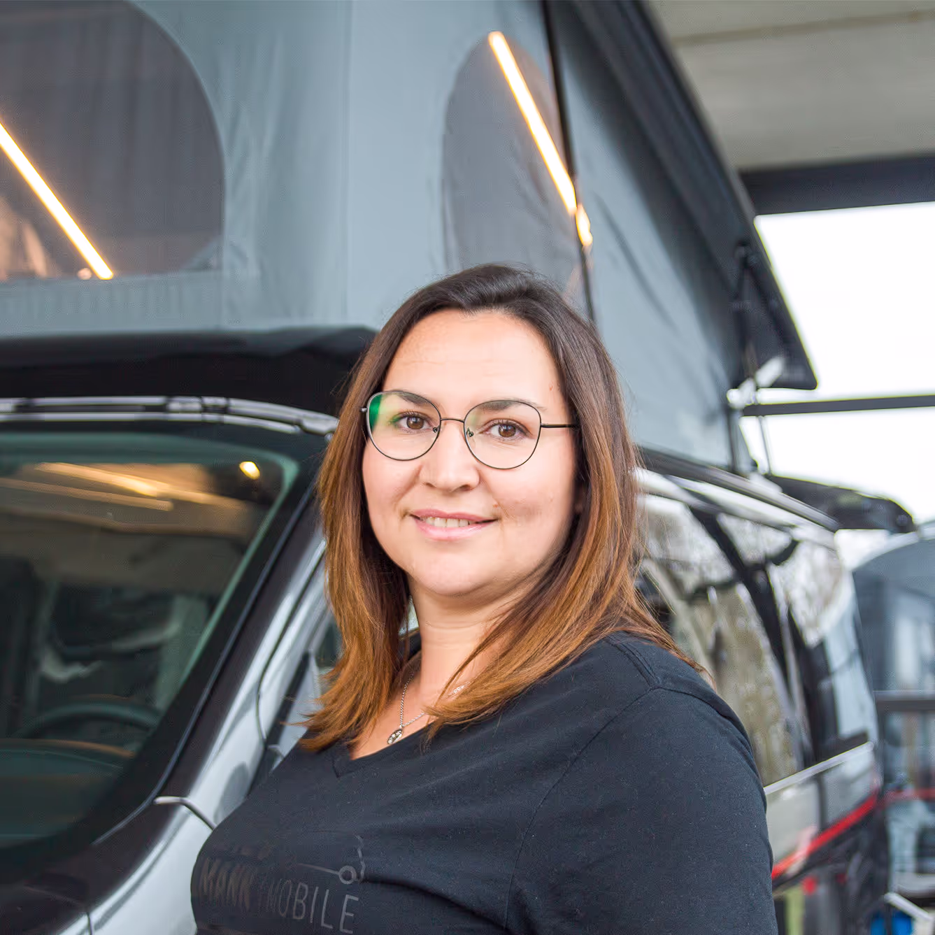 Aleksandra Dick_Teiledienstleitung Aleksandra Dick von Hartz & Hackmann Mobile vor einem Wohnmobil im Showroom