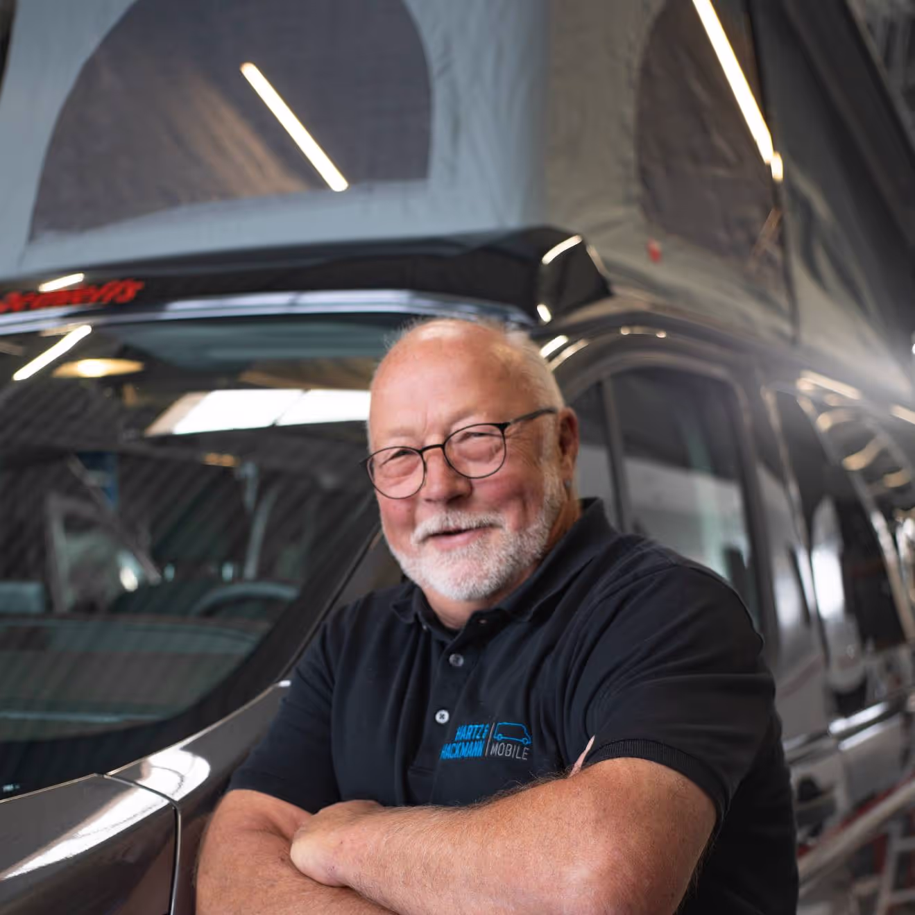 Anton-Blömer-Chefeinweiser Anton Blömer von Hartz & Hackmann Mobile vor einem Wohnmobil im Showroom
