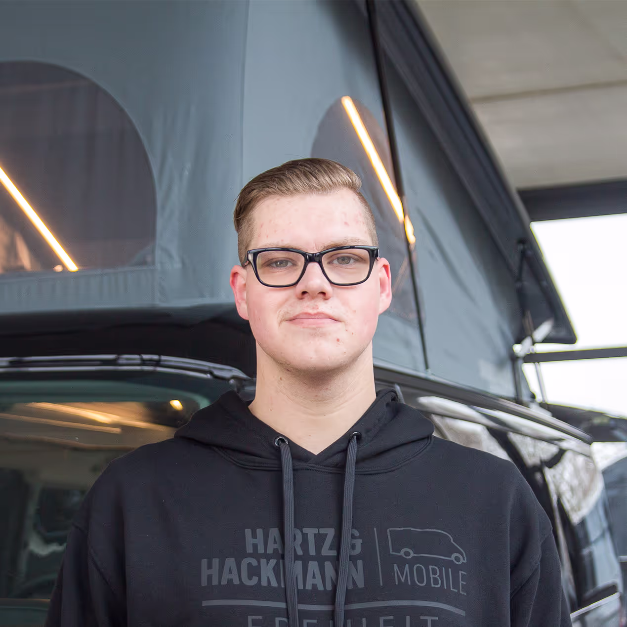 Florian Krethen_Fahrzeugwäsche Florian Krethen von Hartz & Hackmann Mobile vor einem Wohnmobil im Showroom