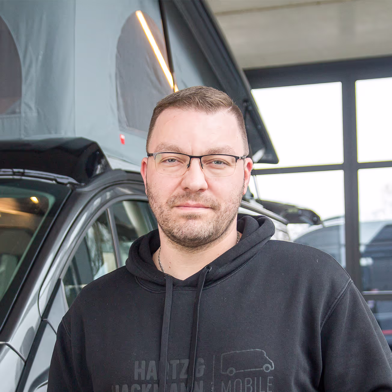 Michael Kern_Serviceberatung Michael Kern von Hartz & Hackmann Mobile vor einem Wohnmobil im Showroom
