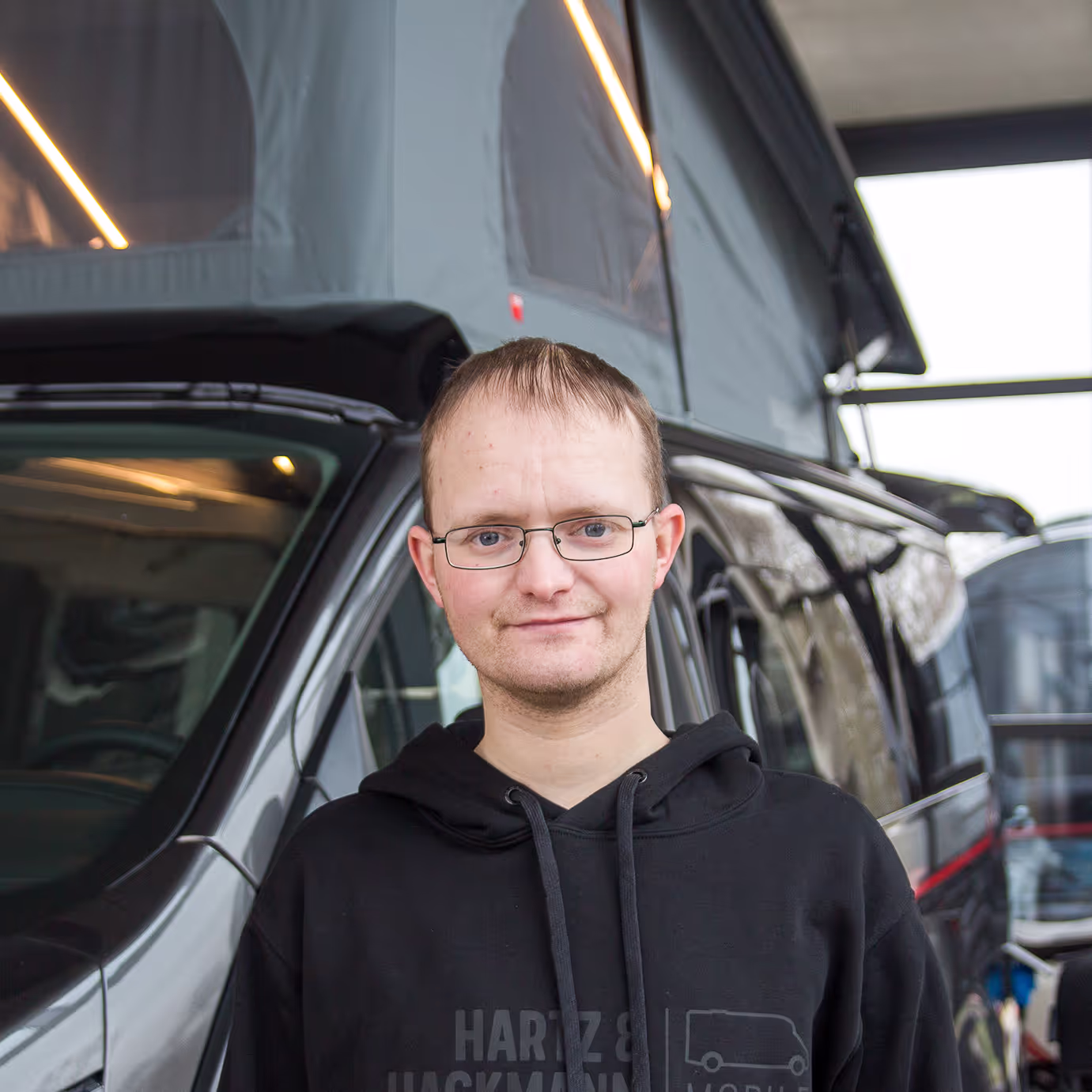 Mike-Fitzner-Fahrzeugwäsche Mike Fitzner von Hartz & Hackmann Mobile vor einem Wohnmobil im Showroom