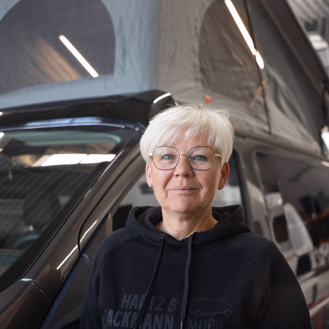 Rita-Werneke-Vermietung Rita Werneke von Hartz & Hackmann Mobile vor einem Wohnmobil im Showroom