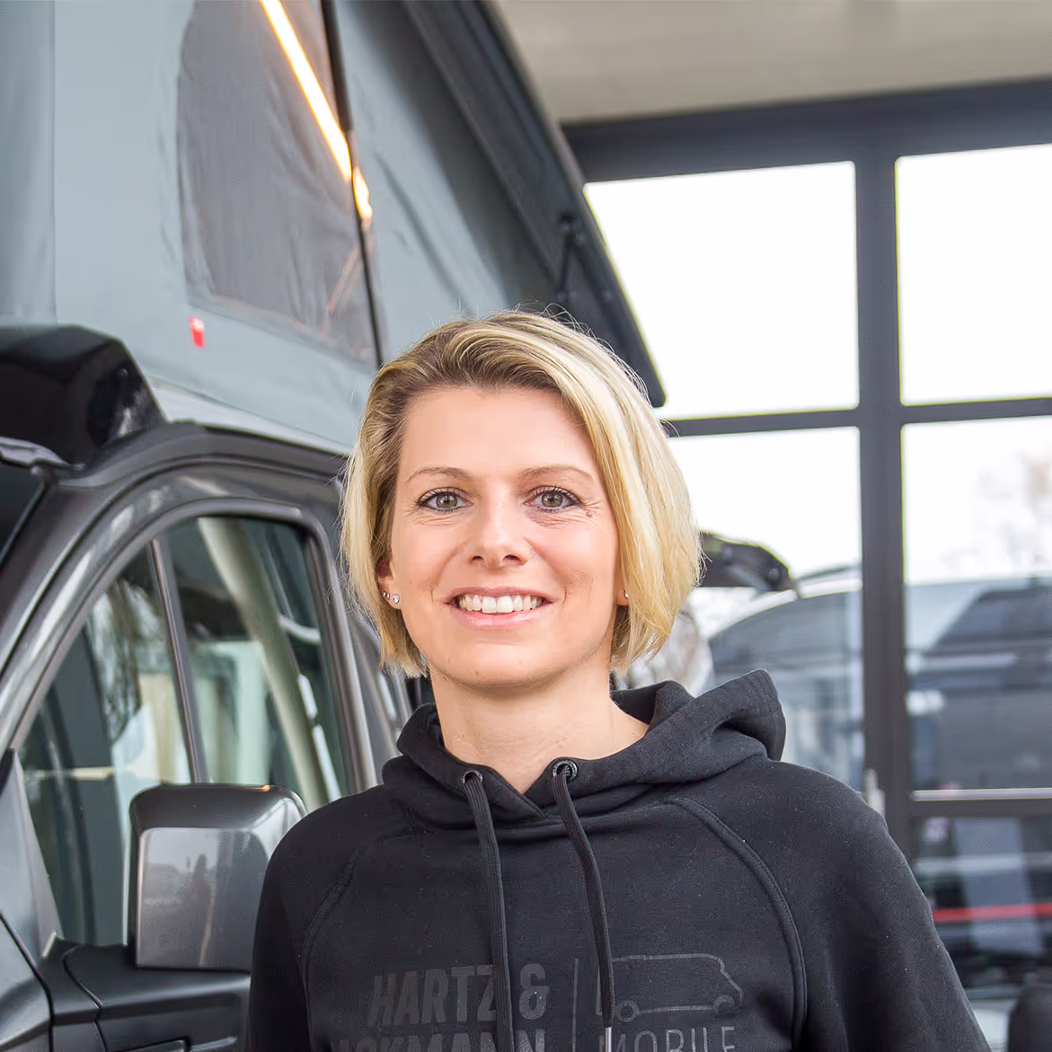 Svenja Küttner_Buchhaltung Svenja Küttner von Hartz & Hackmann Mobile vor einem Wohnmobil im Showroom