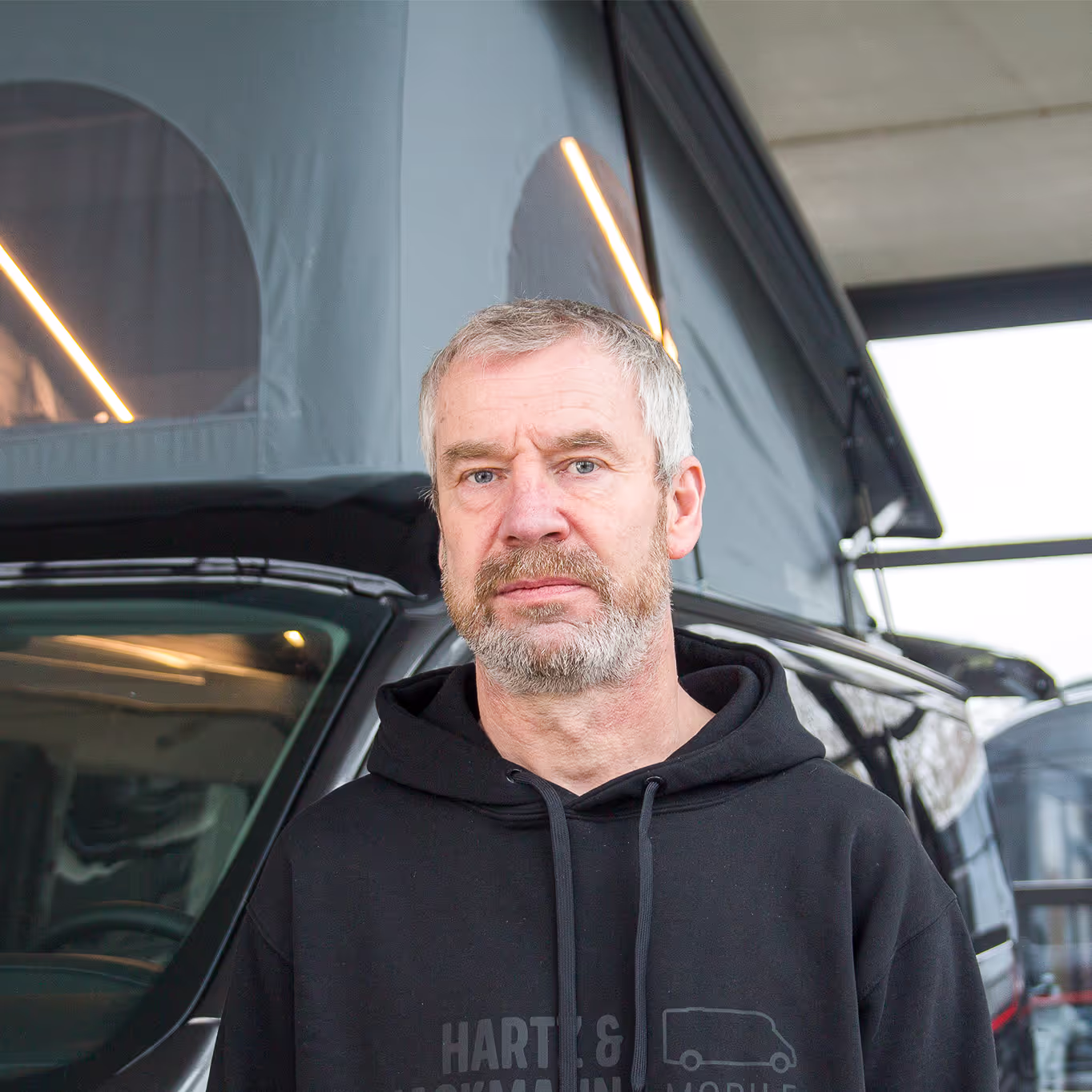 Thomas-Meyer-Werkstattleitung Thomas Meyer von Hartz & Hackmann Mobile vor einem Wohnmobil im Showroom
