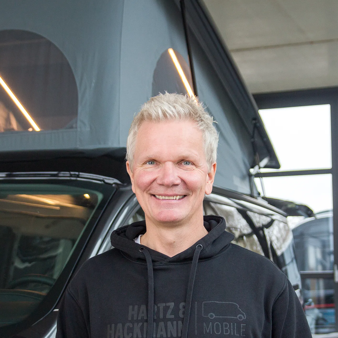Ulrich_Hartz_Geschäftsführung Ulrich Hartz von Hartz & Hackmann Mobile vor einem Wohnmobil im Showroom