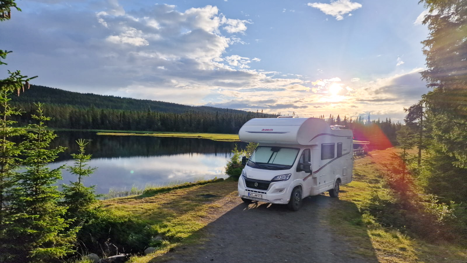 Wohnwagen parkt in Norwegen am See bei Sonnenuntergang
