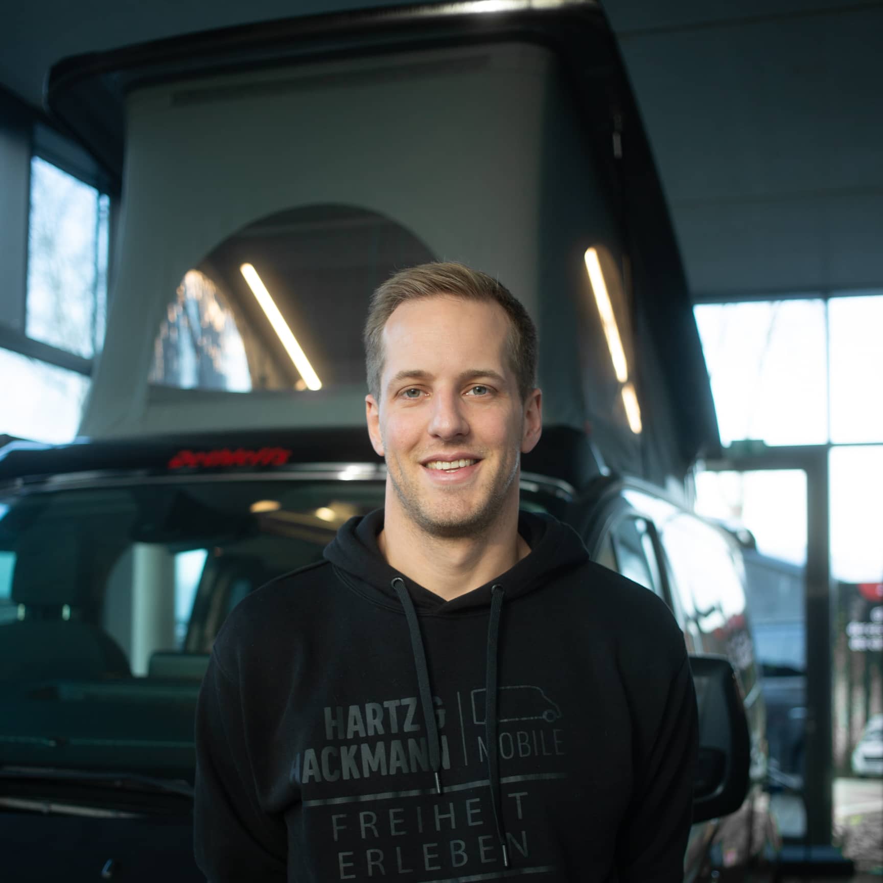 Frank-Broering-KFZ-Meister KFZ-Meister Frank Bröring von Hartz & Hackmann Mobile vor einem Wohnmobil im Showroom